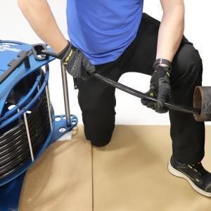 A man is operating a pipe-cleaning machine.